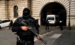 Un policier armé monte la garde devant le palais de Justice de Paris, alors qu'arrive le van transportant Jawad Bendaoud, le 24 janvier 2018