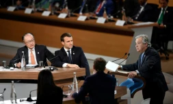 Le président de la Banque mondiale Jim Yong Kim et Emmanuel Macron écoutent le secrétaire général des Nations-Unies Antonio Guterres, à  l'île Seguin à Boulogne-Billancourt, à l'ouest de Paris le 12 décembre 2017