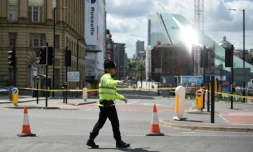Un policier assure le périmètre de sécurité autour de la salle de concert Arena, théâtre d'un attentat meurtrier à Manchester, au Royaume-Uni, le 23 mai 2017