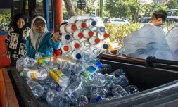 Des dizaines de personnes échangent des bouteilles en plastique contre des tickets à la gare routiÚre de Surabaya, en Indonésie, le 21 juillet 2019