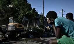Des habitants assistent à la démolition des cases en tôle du bidonville Talus 2, le 22 mai 2023 à Mayotte