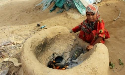 Une petite fille yéménite qui a fui la guerre dans la région de Harad, fait bouillir de l'eau dans un camp de déplacés à Abs dans la province de Hajjah, le 23 juillet 2017 