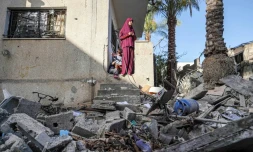Une femme palestinienne constate les dommages subis par la maison familiale à Nuseirat (centre), le 23 mai 2024, à la suite des bombardements israéliens sur la bande de Gaza