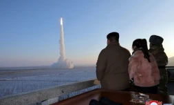 Photo diffusée par KCNA le 19 décembre 2021 du dirigeant nord-coréen Kim Jong Un (G) et de sa fille qui assistent au tir d'un missile Hwasong-18 de classe ICBM