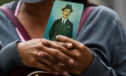Une femme tient dans ses mains une image de José Gregorio Hernandez (1864-1919), "le médecin des pauvres", héros national vénézuélien, pendant la créméonie de béatification le 30 avril 2021 à Caracas