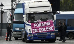 Des policiers devant un cortège de camions de forains, le 12 septembre 2017 à Paris
