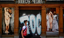 Un jeune homme passe devant un bar fermé à Madrid, en Espagne, le 9 juillet 2020