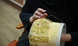 La religieuse chrétienne orthodoxe sœur Élisabeth brode au fil doré des motifs et détails sur une mitre, au monastère de Saint-Georges le Victorieux à Rajcica, le 18 juin 2025 en Macédoine du Nord