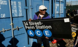 Le réalisateur Spike Lee tient une panneau d'une station de métro qu'il vient d'acheter lors de la vente annuelle organisée par la régie des transports de New York (MTA), le 9 octobre 2026