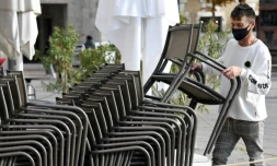 Le propriétaire d'un café de Stuttgart en Allemagne empile les chaises en raison de la fermeture de son établissement le 2 novembre 2020