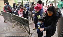 Des femmes et des enfants attendent pour se faire tester au Covid-19, le 23 février 2022 à Hong Kong
