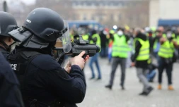 Un policier vise des manifstants avec un LBD, place de l'Etoile à Paris le 12 janvier 2019