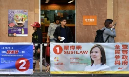 Des passants devant des affiches électorales dans le quartier de Wanchai à Hong Kong le 22 novembre 2019