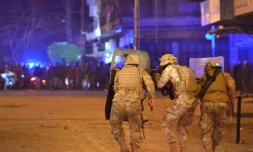 Des forces de sécurité libanaises prennent position durant des affrontements avec les manifestants anti-gouvernementaux le 27 janvier 2021 à Tripoli, dans le nord du Liban