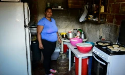 Gabriela Vega prépare dans sa cuisine un repas pour la cantine solidaire qu'elle dirige dans la favela La Vega, le 28 février 2018 à Caracas, au Venezuela