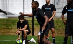 Le défenseur d'Amiens Valentin Gendrey (g) et certains de ses coéquipiers prennent part à la reprise de l'entraînement sur un terrain situé près du Stade de la Licorne, à Amiens le 25 juin 2020.