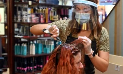 Coiffeuse à Birkenhead, dans le nord-ouest de l'Angleterre, le 4 juillet 2020, date d'une nouvelle étape du déconfinement avec la réouverture des salons de coiffure, pubs, restaurants