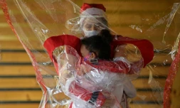 Calin par temps de Covid-19 entre une bénévole et un enfant de Belo Horizonte dans l'Etat du Minas Gerais au Brésil, le 7 décembre 2020