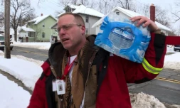 Un volontaire de la Croix rouge américaine livre des packs de bouteilles d'eau aux habitants de Flint