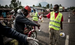 Un conduteur de moto-taxi se fait laver les mains sur la route entre Butembo et Goma, en RD Congo, dans le cadre de la lutte contre l'épidémie d'Ebola, le 16 juillet 2019