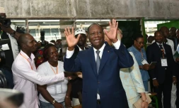 Le président ivoirien Alassane Ouattara salue la foule à son arrivée au bureau de vote, le 25 octobre 2015 à Abidjan, lors de l'élection présidentielle