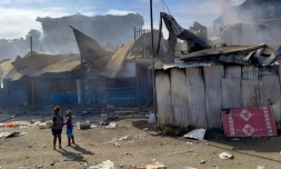 De la fumée s'élÚve de bùtisses dans le quartier chinois d'Honiara, le 26 novembre 2021