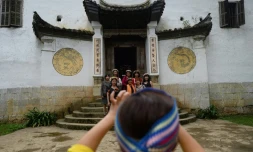Des touristes posent le 26 octobre 2018 devant un ancien palais Hmong à Dong Van, dans le nord du Vietnam