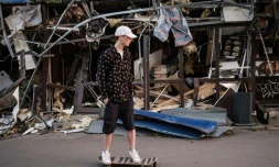 Roman Kovalenko, 18 ans, fait du skateboard près d'un commerce de Kramatrosk (Ukraine) détruit par un missile, le 5 mai 2022