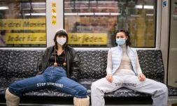 Elena Buscaino (d) et Mina Bonakdar deux militantes féministes écartent leur jambes pour dénoncer l'attitude des hommes qui s'étalent jambes écartés dans le métro à Berlin, le 5 février 2021