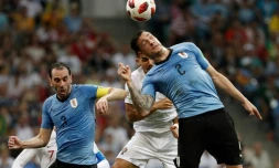 Les défenseurs uruguayens Jose Gimenez (d) et Diego Godin (g) à la lutte avec l'attaquant portugais Andre Silva (c) en 8es de finale du Mondial, à Sotchi, le 30 juin 2018