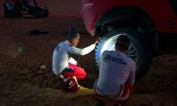 Sebastien Loeb et son co-pilote Fabian Lurquin jettent un oeil à leur Hunter de Prodrive au mitan de l'étape "48h chrono" du Dakar dans le désert de "l'Empty Quarter" en Arabie saoudite le 11 janvier 2024