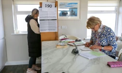 Une électrice (g) dans un bureau de vote lors du référendum destiné à moderniser les références aux femmes et à la famille dans la Constitution irlandaise, sur l'île de Gola, au large de la côte du Donegal, à l'ouest de l'Irlande, le 8 mars 2024