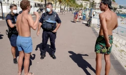 Des policiers patrouillent le long de la promenade des Anglais à Nice le 3 août 2020 pour informer les passants du port du masque obligatoire