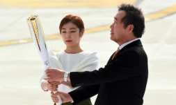 Le Premier ministre sud-coréen Lee Nak-Yon (d) et la médaille d'or du patinage artistique Kim Yu-Na portent la flamme olympique, le 1er novembre 2017 à l'aéroport de Séoul lors d'une cérémonie pour son arrivée en Corée du Sud