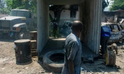 Un homme prÚs de véhicules brûlés prÚs de son garage à Port-au-Prince le 25 mars 2024