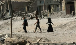 Des irakiens marchent dans les rues détruites de Mossoul, le 13 juillet 2017, quelques jours après que l'armée a chassé le groupe Etat islamique de la ville