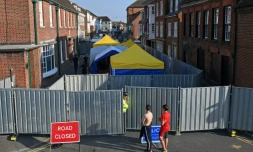 Un policier monte la garde le 5 juillet 2018 devant une barrière interdisant l'accès à une rue d'Amesbury, dans le sud de l'Angleterre, où un couple exposé au Novitchok est tombé malade