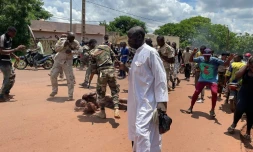 Un homme soupçonné d'avoir participé à une attaque "terroriste" déjouée gît sur le sol après avoir été battu par la foule, devant la base militaire de Kati, au Mali, le 22 juillet 2022