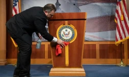 Un employé désinfecte le pupitre de la salle de presse du Sénat américain,
à Washington, le 17 mars 2020