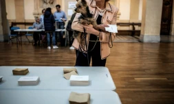 Une électrice porte son chien dans un bureau à Lyon, le 23 avril 2017