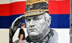 Un homme passe devant une fresque murale représentant l'ancien chef militaire des Serbes de Bosnie, Ratko Mladić, le 6 septembre 2026 à Belgrade, en Serbie, dont l'inhumation est prévue le 7 septembre 2026 au cimetière de Topčider à Belgrade, sur fond de critiques de l'UE concernant la "glorification" d'un criminel de guerre condamné pour génocide