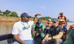 Aristide Takoukam Kamla (g), docteur en biologie marine, spécialiste du lamantin d'Afrique, s'entretient avec des touristes et d'autres biologistes sur un bateau à Dizangue, le 10 décembre 2024 au Cameroun