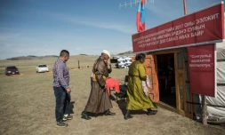 Des personnes entrent dans une yourte transformée en bureau de vote lors de la présidentielle, le 26 juin 2017 à Tuul Valley, en Mongolie