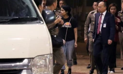 La jeune Saoudienne Rahaf Mohammed al-Qanun (C) est escortée vers un véhicule par un responsable thaïlandais de l'immigration et des délégués du Haut commissariat aux réfugiés de l'ONU, à l'aéroport Suvarnabhumi de Bangkok, le 7 janvier 2019