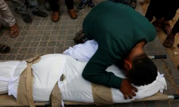 Un homme prosté sur le corps d'une personne tuée dans une frappe israélienne, à l'hôpital Al-Chifa le 4 février 2026