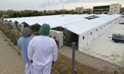 Des soignants regardent la construction d'un hôpital de campagne pour accueillir des patients atteints du Covid-19, le 5 avril 2020 à Valence