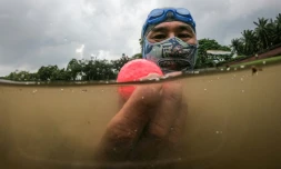 Le plongeur Sumadi Ibrahim repêche une balle de golf dans un étang d'un terrain de Shah Alam, dans la banlieue de Kuala Lumpur, le 11 novembre 2024 en Malaisie
