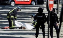 Des policiers recouvrent le corps d'un assaillant, après un attentat avorté sur les Champs-Élysées, le 19 juin 2017 à Paris