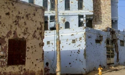 Des enfants soudanais marchent à côté de bâtiments criblés de balles à Omdourman la proche banlieue de Khartoum, le 20 mars 2025