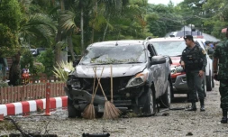 Un soldat thaĂŻlandais inspecte une voiture carbonisĂ©e lĂ oĂč une bombe a explosĂ©, Ă l'extĂ©rieur d'un hĂŽtel dans la province de Pattani (sud), le 24 aoĂ»t 2016